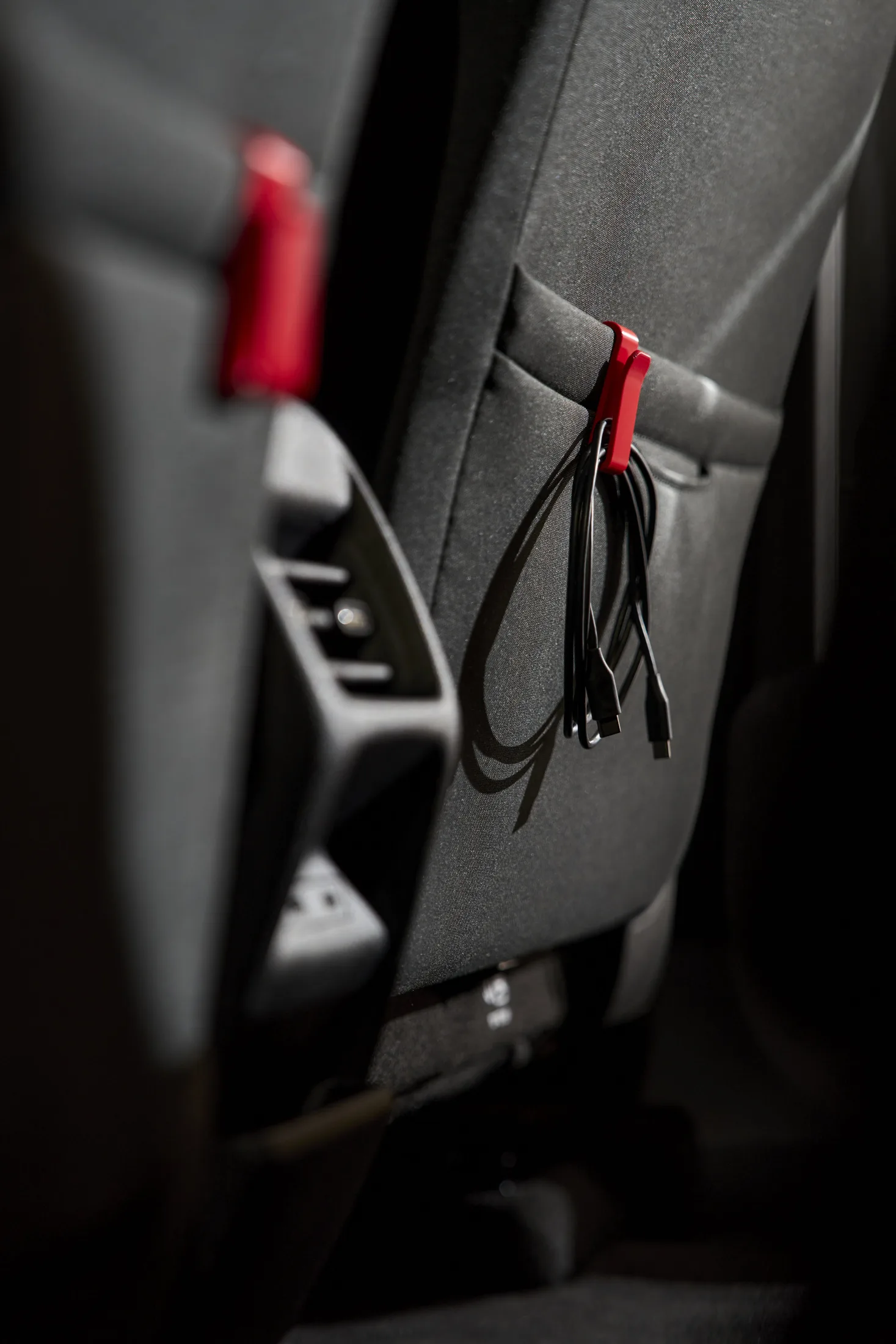 Seat-back pocket hook holding a USB cable